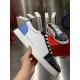 Christian Louboutin Louis Junior Spikes Orlato Handheld View in white and blue Hand holding a white Christian Louboutin Louis Junior Spikes Orlato trainer showing lateral leather panel and spike detail in white and blue