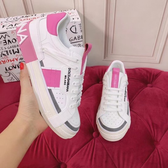 Dolce & Gabbana Custom 2.Zero Trainer In Hand Close-Up in white and pink Hand holding a white and pink Dolce & Gabbana trainer showing side logo patch