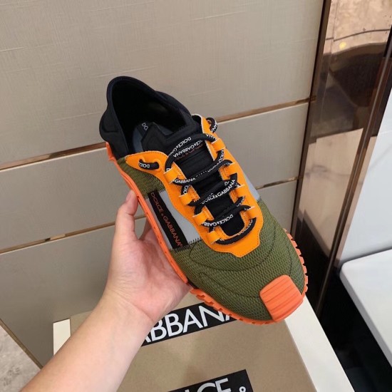 Top-down hand-held view of the Dolce & Gabbana orange and green mesh trainer showing lace detailing