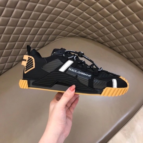 Outer side view of Dolce & Gabbana black trainer held in hand in black and tan
