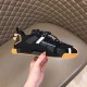 Outer side view of Dolce & Gabbana black trainer held in hand in black and tan
