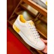 Side Profile of Dolce & Gabbana Trainer in white and yellow Side profile view of white leather trainer held showing yellow heel counter logo