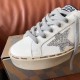 Close-up of Golden Goose trainer toe cap, grey laces, and silver glitter star emblem in white and silver