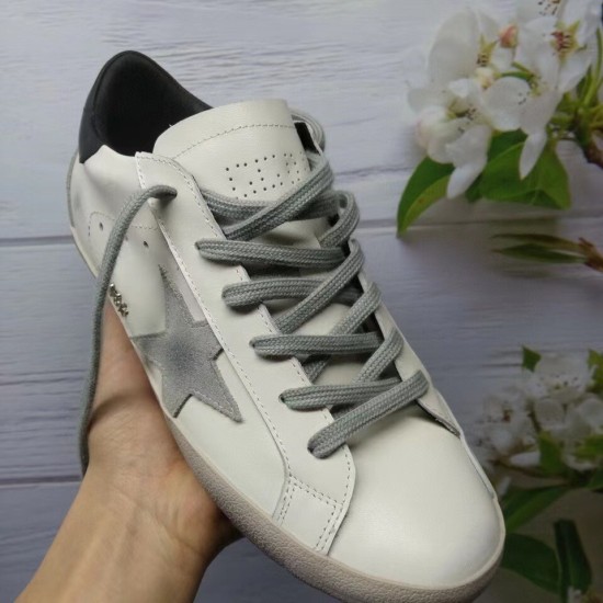 Golden Goose Super-Star White Trainer - Top View in white and grey Top-down hand-held view of a Golden Goose Super-Star white trainer with grey laces