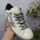 Golden Goose Super-Star White Trainer - Top View in white and grey Top-down hand-held view of a Golden Goose Super-Star white trainer with grey laces