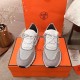 Top-down view of the grey knit low top trainers resting on an orange shoe box