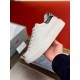 Hand holding a Prada Macro white leather low-top trainer showing the side mid-sole profile in white and black