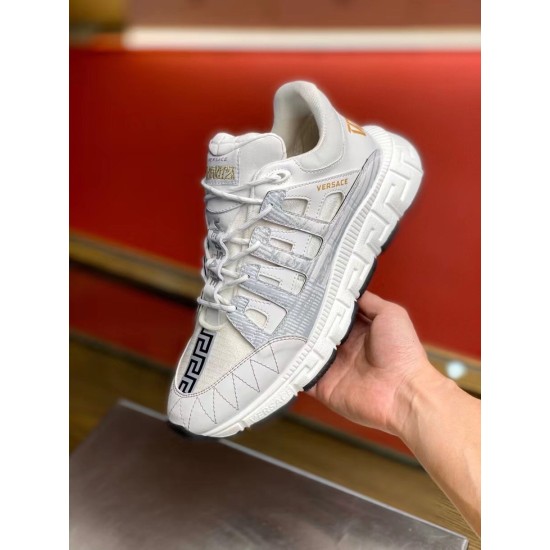 Versace Trigreca Low Top White Trainer Angle View in white and gold Hand holding Versace Trigreca Low Top White Trainer showing front panel and side profile in white and gold
