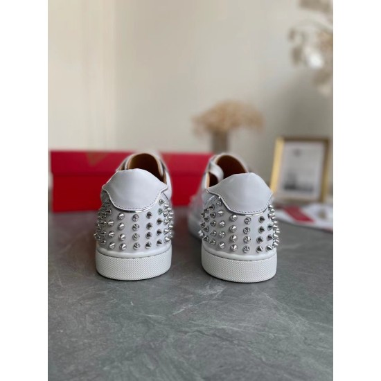Rear view of Christian Louboutin white trainers displaying spike-embellished heel counters in white and silver