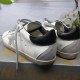 Golden Goose Super-Star Trainers - Heel View in white and grey Rear view showing black leather heel tabs and grey suede heel counters on Golden Goose Super-Star trainers in white and grey