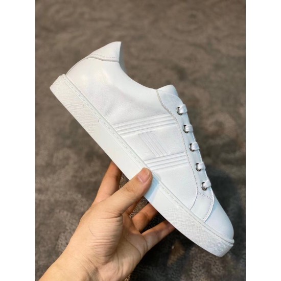 Single Hermes Avantage white leather trainer side profile held in hand