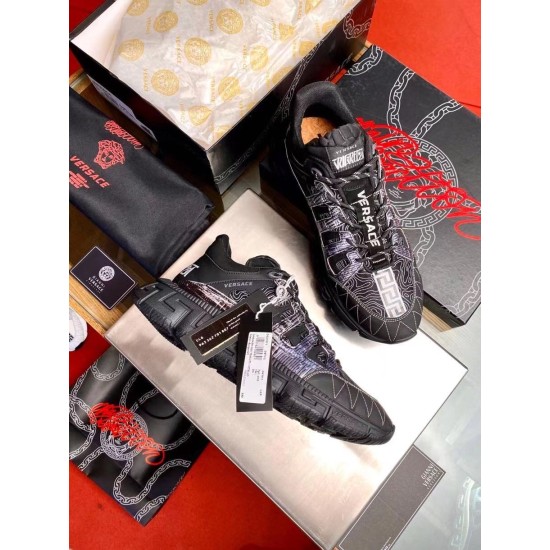 Versace Trigreca Black Trainers Packaging View Top-down view of Versace Trigreca black trainers next to luxury branded packaging and accessories