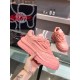 Side profile of a pink Versace Odissea trainer held up, highlighting the sculpted overlays and platform sole