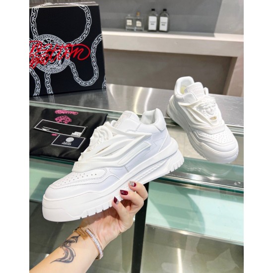 Side view of individual white leather Versace Odissea trainer held in hand