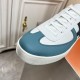 Close-up of blue textured toe cap overlay on Hermes Boomerang trainer in white and blue