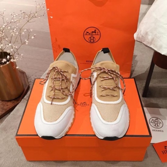 Hermes Addict Knit Trainers Beige White Front Angle Front view of Hermes Addict Knit Trainers in beige and white sitting on an orange shoe box