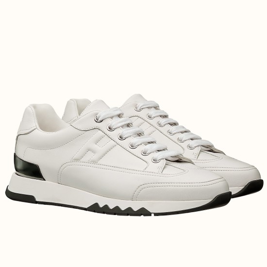 White Trail Leather Low Top Trainers Side View in white and black Pair of white leather Trail low top trainers with black heel clip accents shown at a three-quarter angle.