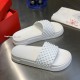 Pair of Christian Louboutin white spiked pool slides next to packaging