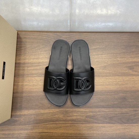 Top-down view of a pair of black calfskin slides displaying the embossed strap logo in black and white