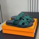 Hermes Chypre Suede Sandals In Dark Green - Angled Box View Angled perspective of Hermes Chypre dark green suede sandals on an orange box