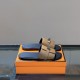 Hermes Gabriel brown and black leather sandals resting on an orange box in brown and silver