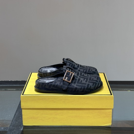Pair of Fendi black logo slippers resting on top of a yellow brand box