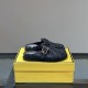 Pair of Fendi black logo slippers resting on top of a yellow brand box