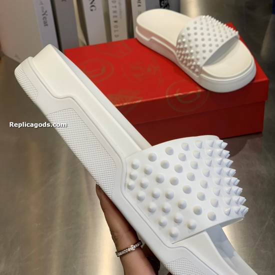 Close-up of Christian Louboutin white spiked pool slide held in hand