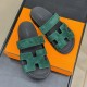 Hermes Chypre Suede Sandals In Dark Green - Top Down View Top-down view of Hermes Chypre dark green suede sandals resting on an orange box