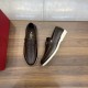 Valentino Men's brown loafers displayed beside a red branded box on wooden surface in brown and white