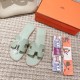 Hermes Oran Flat Sandals In Light Green - Flat Lay with Accessories Top view of light green sandals shown next to two patterned silk twill ribbons and a box