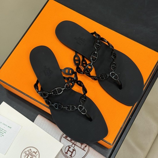 Hermes black Island Sandals overhead layout Top down view of Hermes black Island Sandals resting on an orange box with branding visible