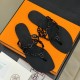 Hermes black Island Sandals overhead layout Top down view of Hermes black Island Sandals resting on an orange box with branding visible