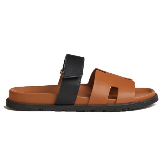 Hermes brown and black sandals side view Side profile of Hermes brown leather sandals showing the black adjustable strap and flat sole