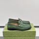 Men's Green Perforated Leather Horsebit 1953 Loafers Pair View in green and silver Pair of Men's Green Perforated Leather Horsebit 1953 Loafers shown resting on a green patterned shoe box in green and silver