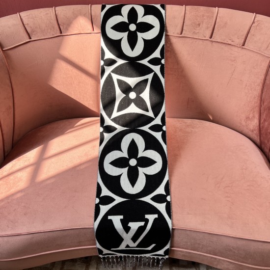 L Women's Medallion Monogram Fringe Black Scarf Black Side View in black and white L Women's Medallion Monogram Fringe Black Scarf draped over a pink sofa showing black main side in black and white