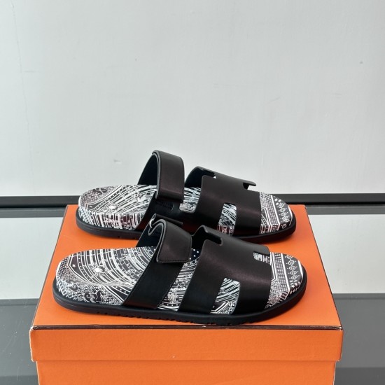 Pair of Hermes Chypre Astrologie black leather sandals displayed together on an orange box