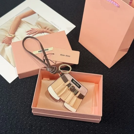 Miu Miu Women's Leather Jacket Trick Keychain Bag Charm resting inside its branded pink presentation box