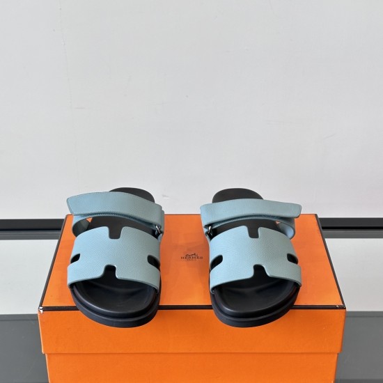 Hermes Chypre Blue Leather Flat Sandals - Front View Front angle view of Hermes Chypre blue leather flat sandals showcasing the H-cutout straps