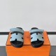 Hermes Chypre Blue Leather Flat Sandals - Front View Front angle view of Hermes Chypre blue leather flat sandals showcasing the H-cutout straps