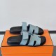 Hermes Chypre Blue Leather Flat Sandals - Box Pair Side Pair of Hermes Chypre blue leather flat sandals resting on an orange box viewed from the side