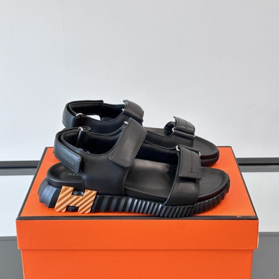 Hermes Black Sandals on Orange Box in black and white Lateral angle view of the black sandals resting on an orange box in black and white