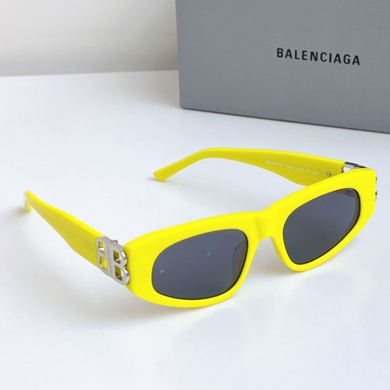 Balenciaga Women's Narrow Yellow Frame Sunglasses Side Angle High-angle side view of Balenciaga Women's Narrow Yellow Frame Sunglasses alongside grey brand packaging box