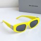 Balenciaga Women's Narrow Yellow Frame Sunglasses Side Angle High-angle side view of Balenciaga Women's Narrow Yellow Frame Sunglasses alongside grey brand packaging box