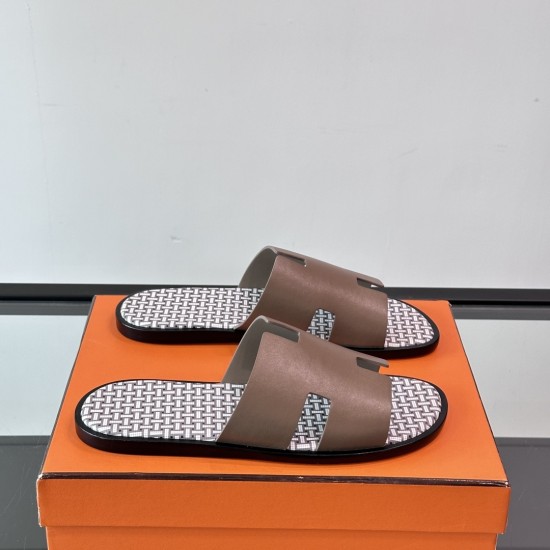 Angled view of Hermes Izmir Sandals in etoupe resting on an orange box
