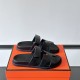 Hermes Chypre Black Leather Sandals Box Side Angle Hermes Chypre black leather sandals displayed on orange box side angle