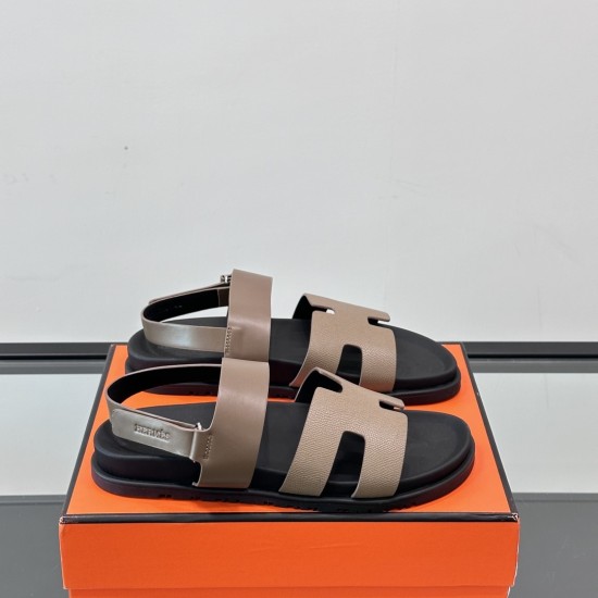 Hermes Genius Sandals in Etoupe Leather resting on an orange box in black