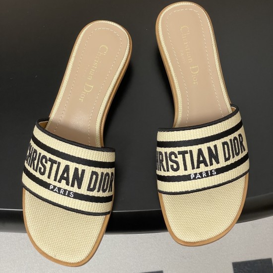 Top down view of Dior natural and black raffia slides Top down view of Dior natural raffia slides displaying embroidered straps and branded insoles in black
