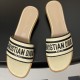 Top down view of Dior natural and black raffia slides Top down view of Dior natural raffia slides displaying embroidered straps and branded insoles in black