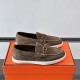 Hermès Men's Ignacio Suede Loafers in Étoupe Brown - Side View Hermès Men's Ignacio Suede Loafers in Étoupe Brown side profile on orange presentation box